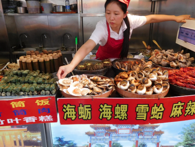 woman preparing egg dish on wangfujing snack street