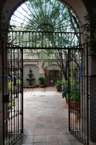 black gated doorway into cobblestone square