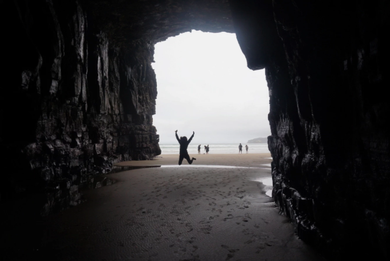 girl jumping in cathedral cave