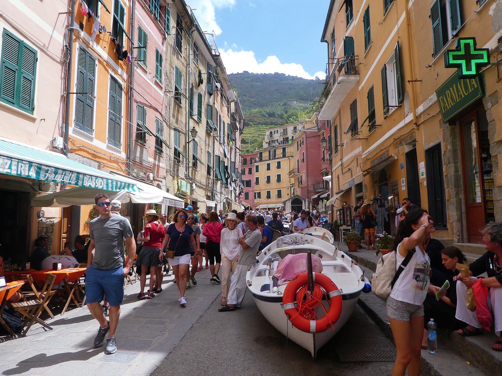 hustle and bustle of tourists in vernazza cinque terre, walking around a fishing boat