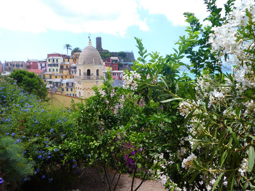 yellow antique clock tower of vernazza as taken from its hiking trail