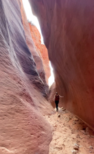 girl walking through narrow red slot canyon