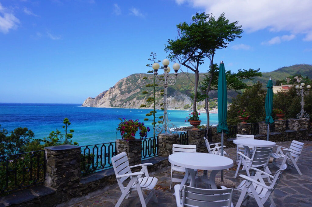 white table and chairs at a cafe on the coast of monterosso al mare