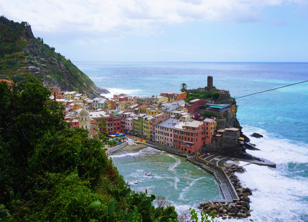 vibrantly colored buildings in vernazza peninsula surrounded by blue water
