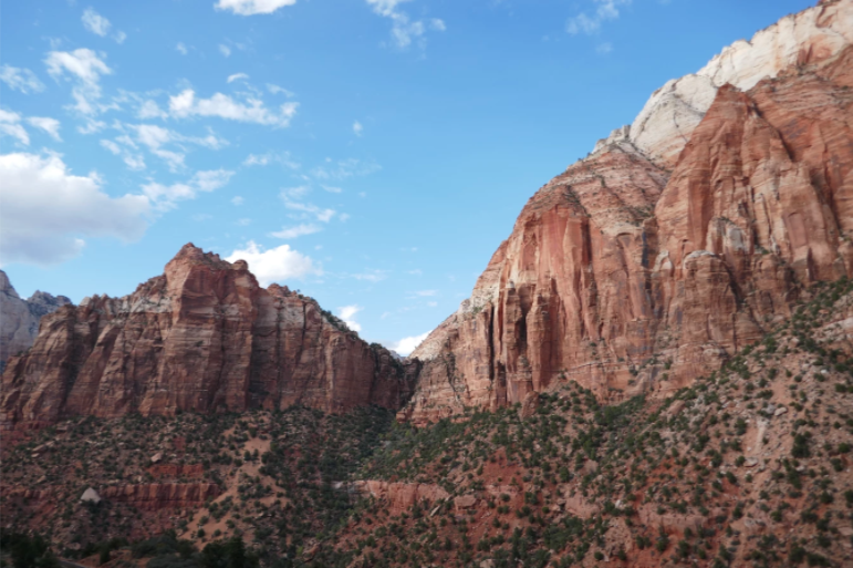 tall rock formations with green plants and blue sky