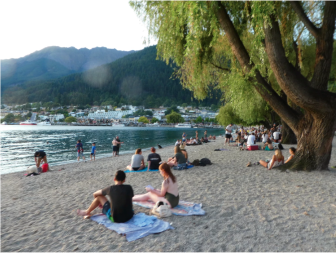 people sitting on towel on sand beach