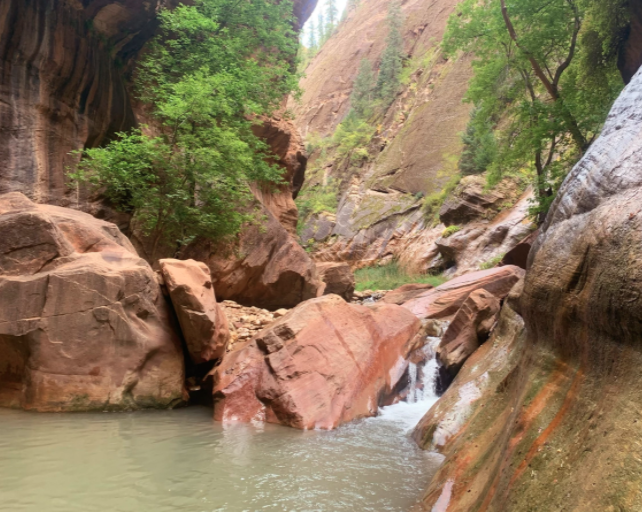waterfall running down the river over red rock