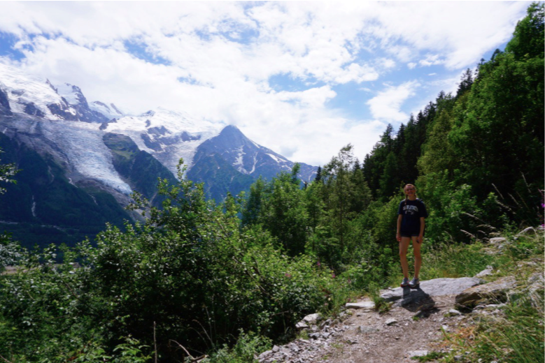 girl standing in front of trees on the mountain