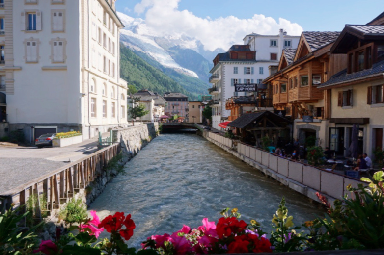 the view of the arve river from the wooden bridge with buildings