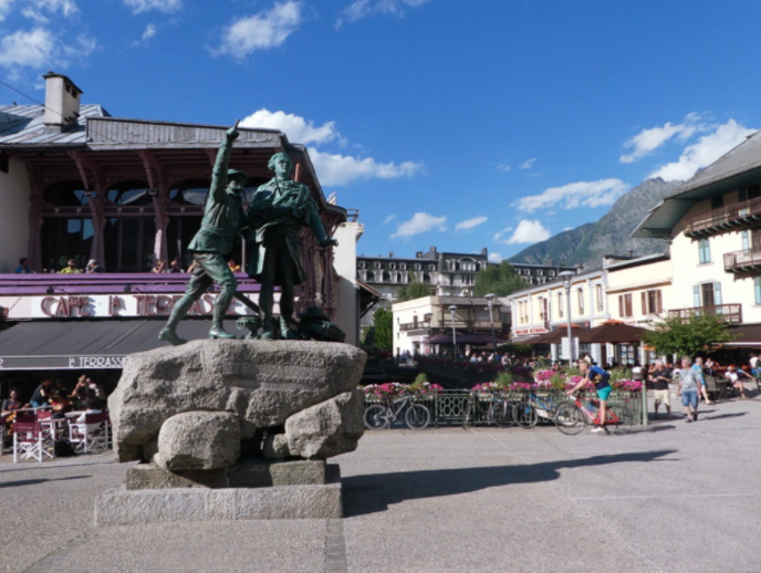 green statue of two men in town plaza