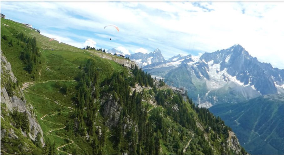 green field on the mountain that paragliders jump off of