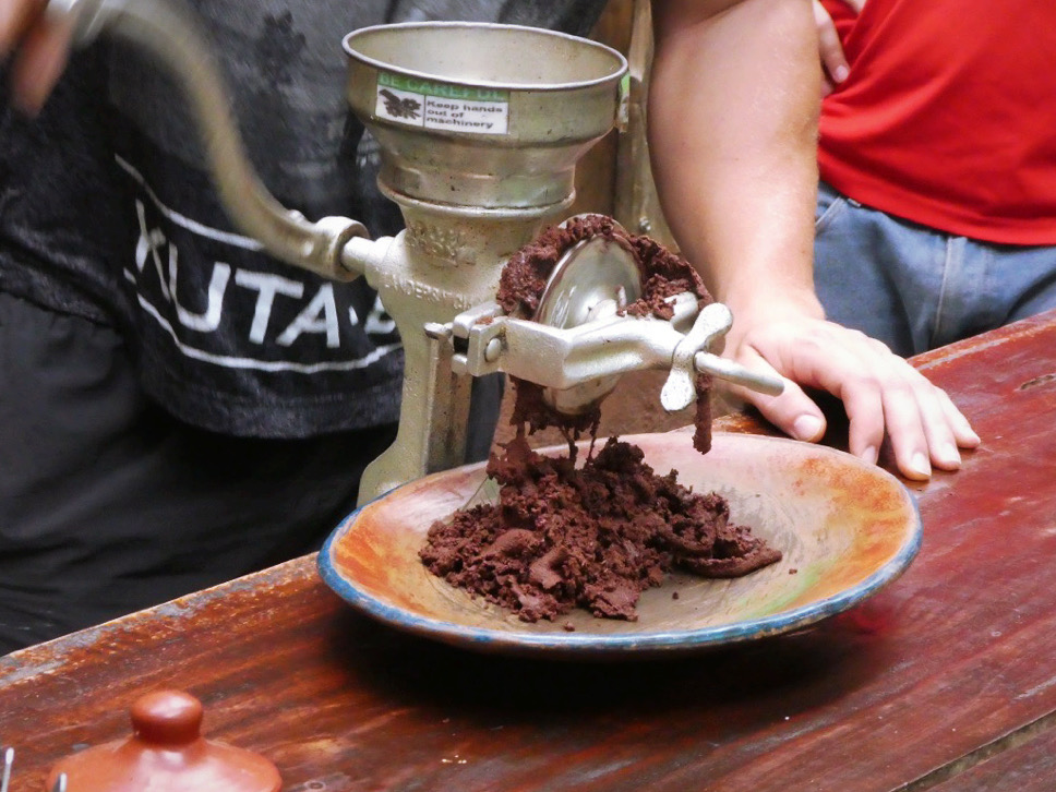 cacao beans being ground into a paste manually