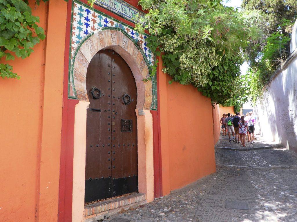 mosaic archway on an orange street wall