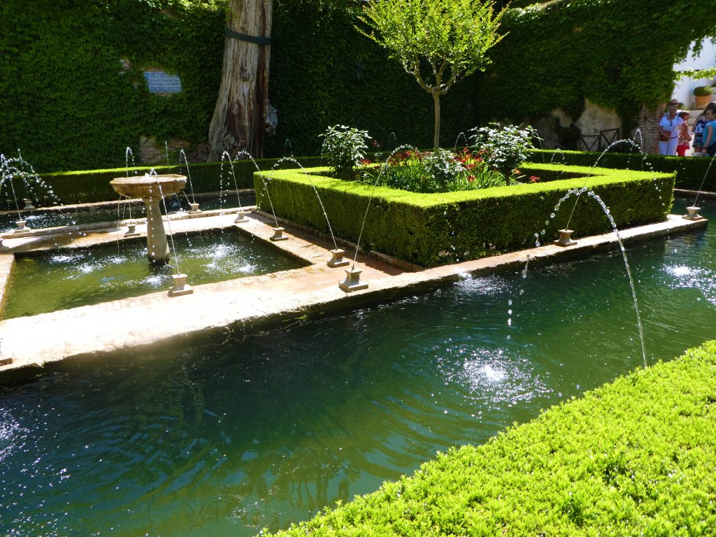 green water fountains with green bush boarders