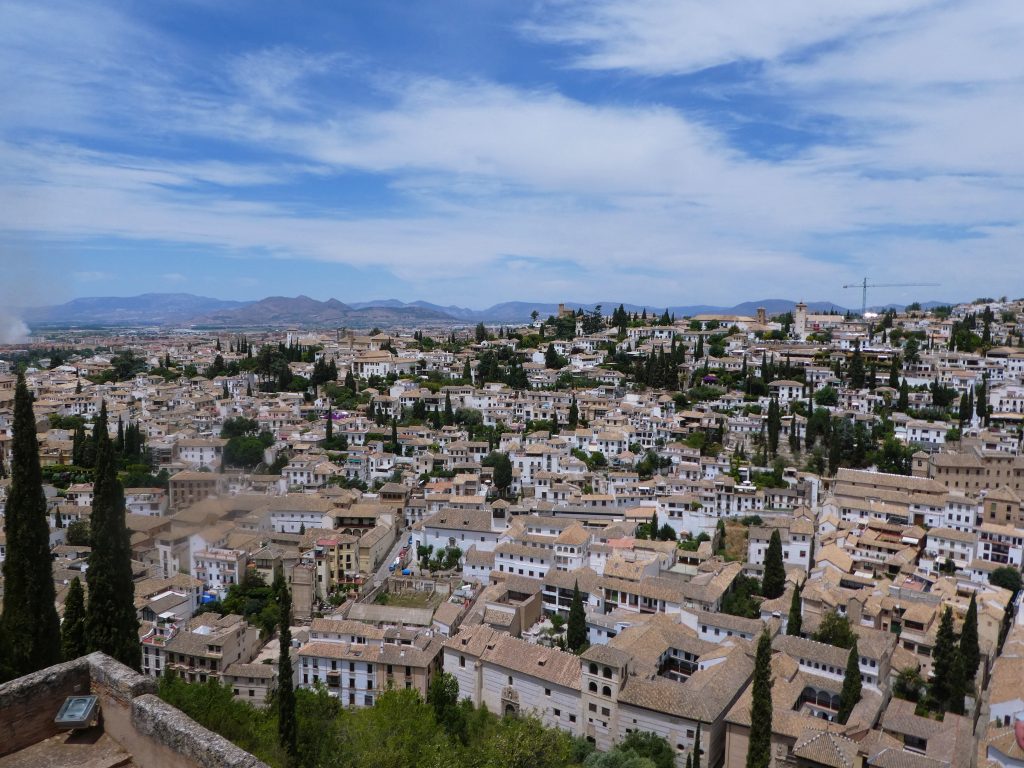 white city of granada with tan roofs and blue sky