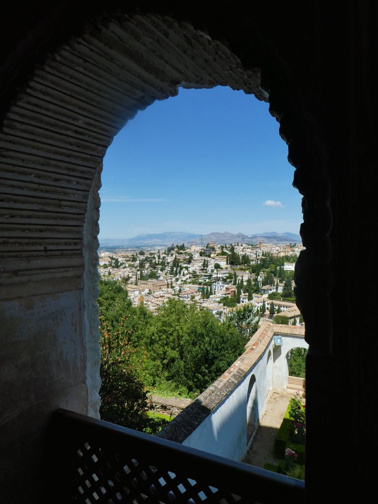 the view of granada from a highly contrasted arched window