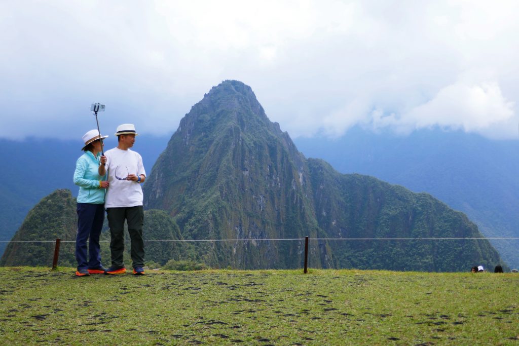 tourists taking a selfie in front of machu picchu