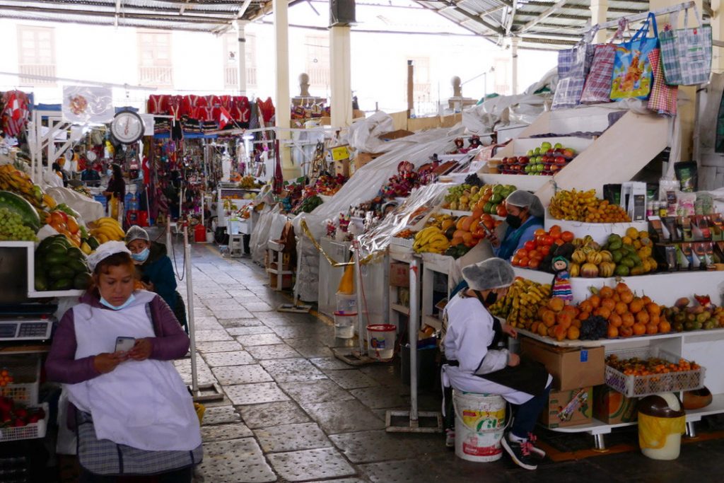a mostly empty aisle in the san pedro market with natural light