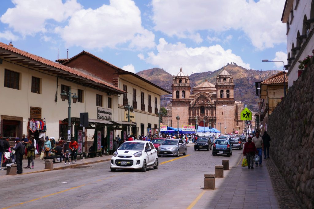 cars driving down a busy street with mountains in the background