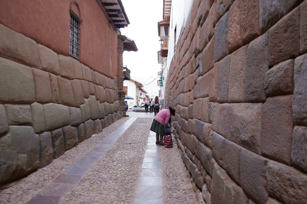 woman picking up her bag in stone alley