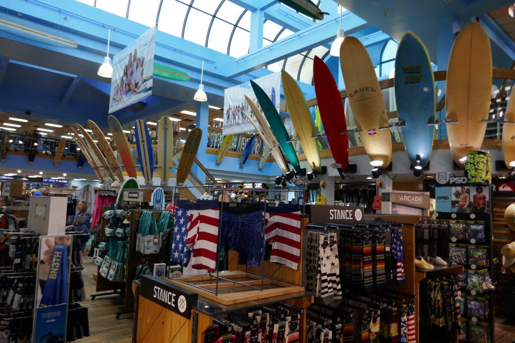 surf boards lined up on a wall in a store