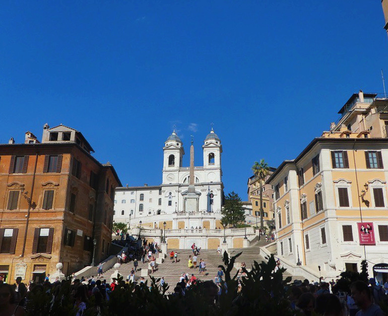 wide steps with people walking up to a white building