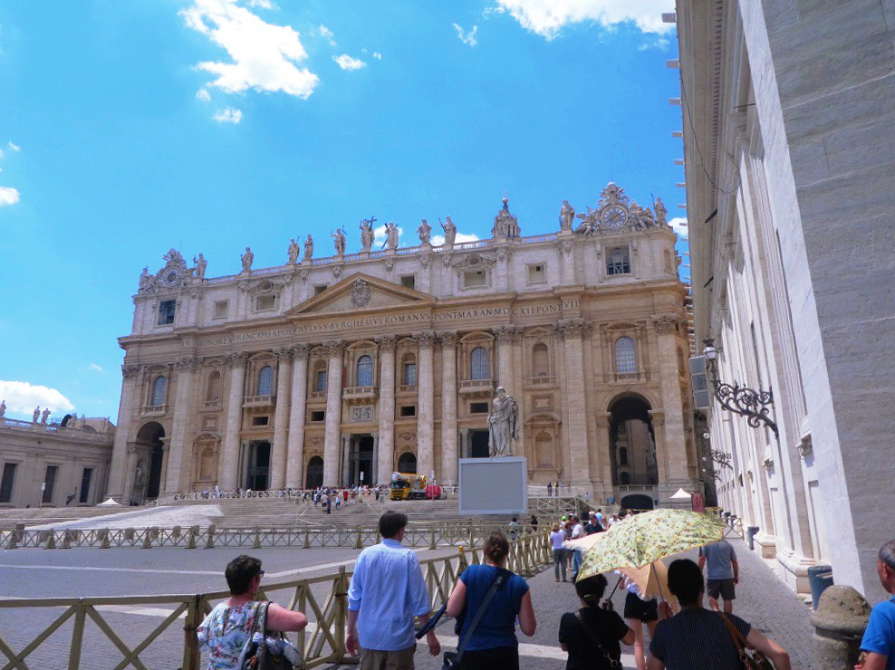 people walking up to the entrance of a columned building