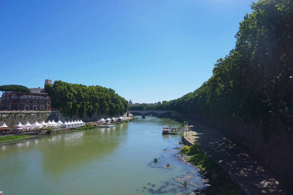 tiber river with green trees lining either side