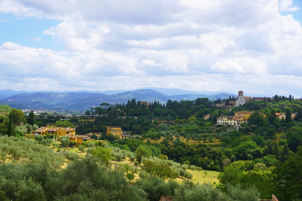 drak green trees and rolling hills in countryside of florence
