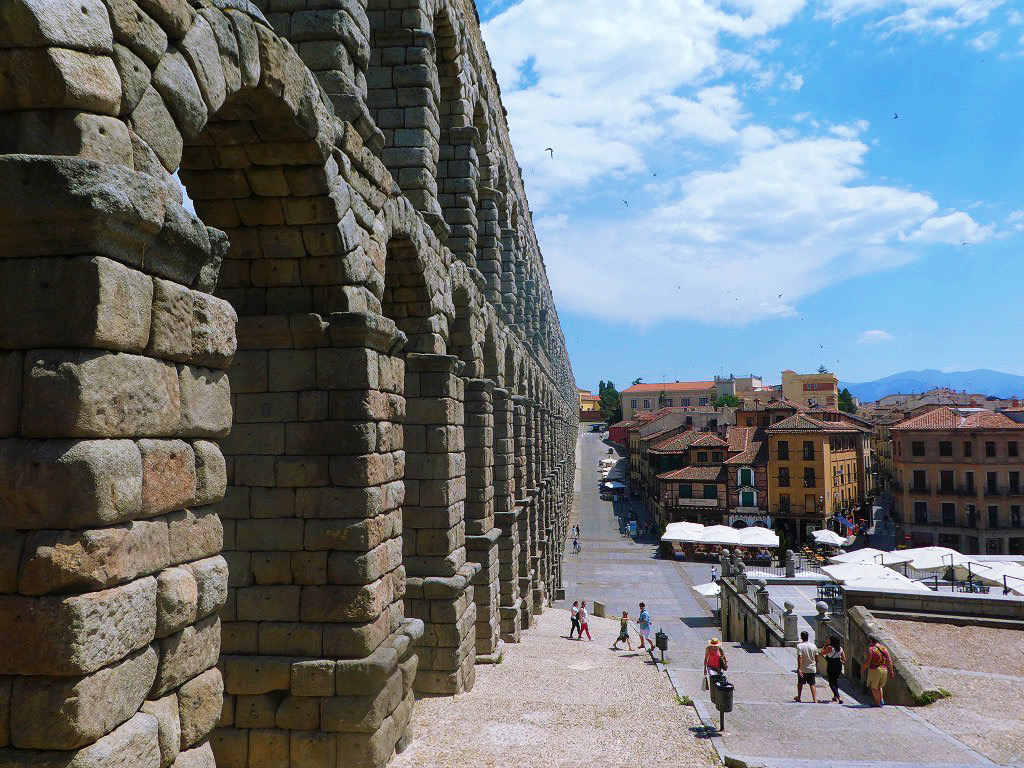 side view of the stone segovia aqueduct as seen from the adjacent stairs