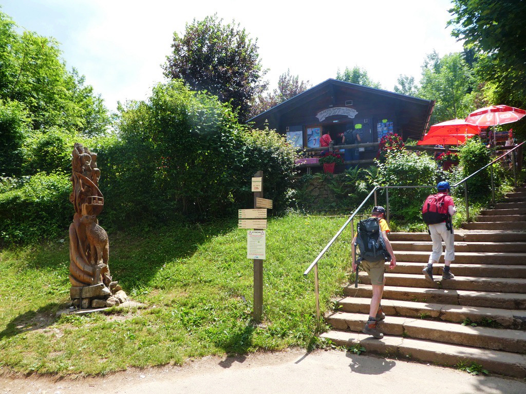 people walking up stairs next to grass and restaurant
