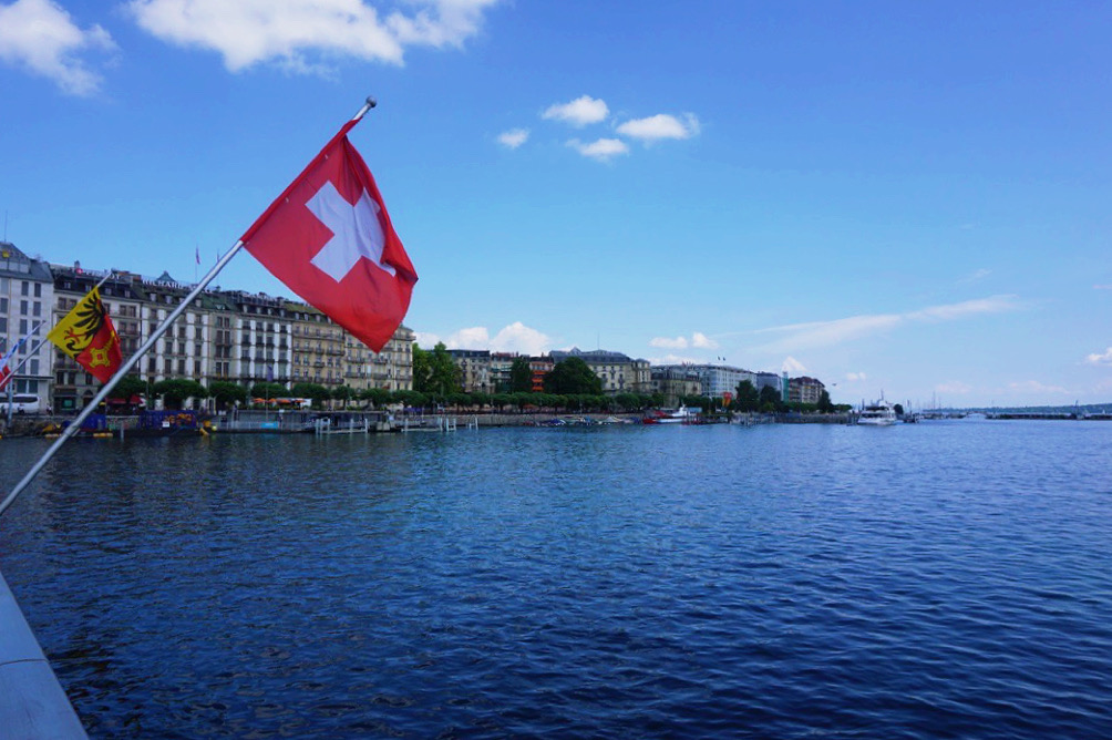 Swiss flag hanging over lake geneva