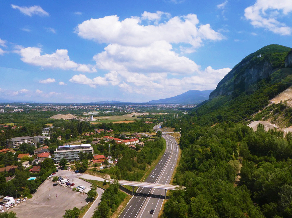 view of a road and green mountain from a cable car