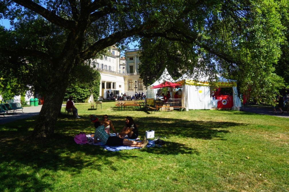 people sitting in the shade at a park fair