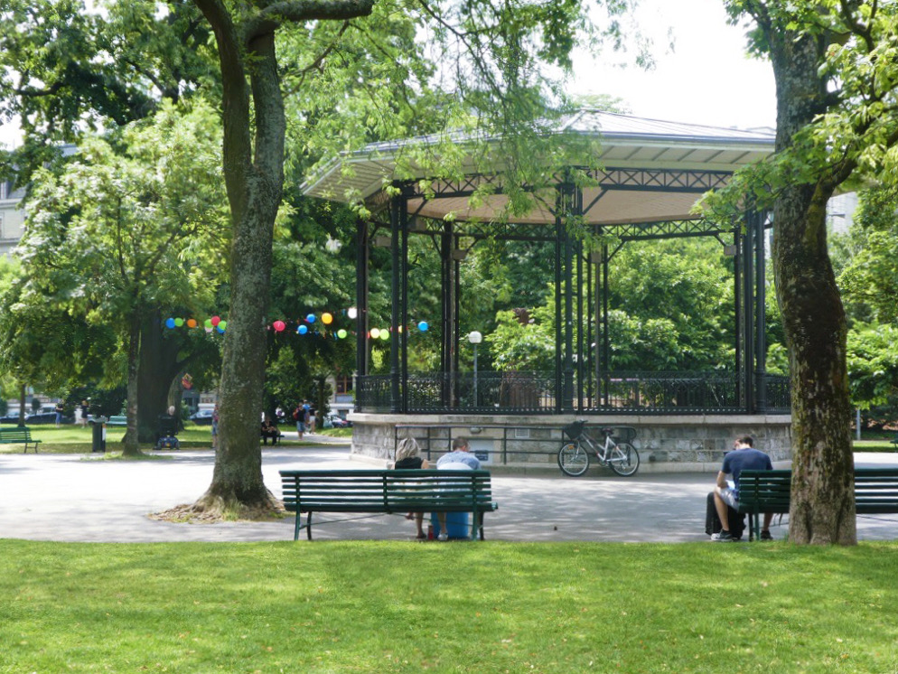man sitting on a bench in front of a gazebo