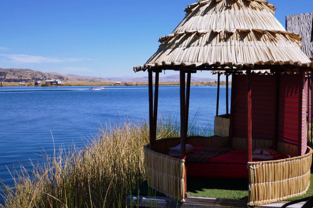 totora reed cabana in front of blue water of lake titicaca