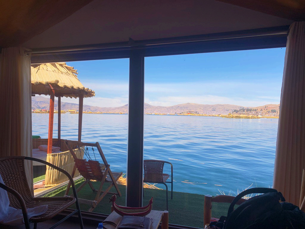 view of lake titicaca through glass windows from inside hotel room