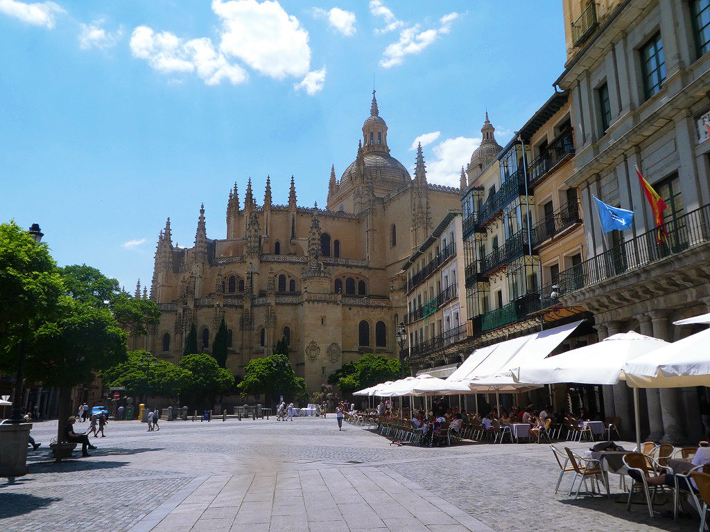 lunch tables in the open plaza of segovia with the cathedral in the background on a sunny day