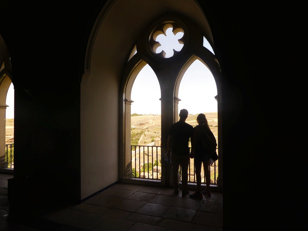 silhouette of two people in the window of the castle of segovia