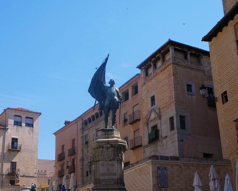 gray statue of a man raising a banner