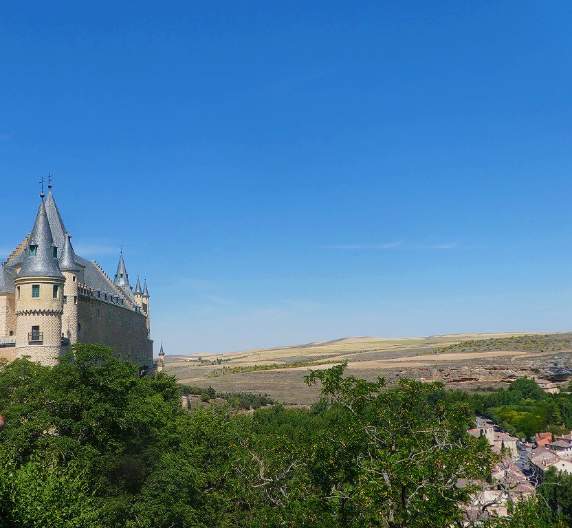 pointed spire of the castle in segovia with deep blue sky in the background