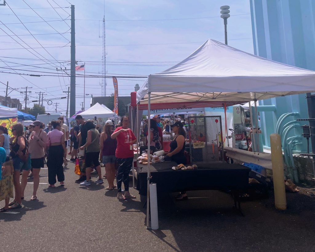 crowded farmers market beneath the stone harbor water tower