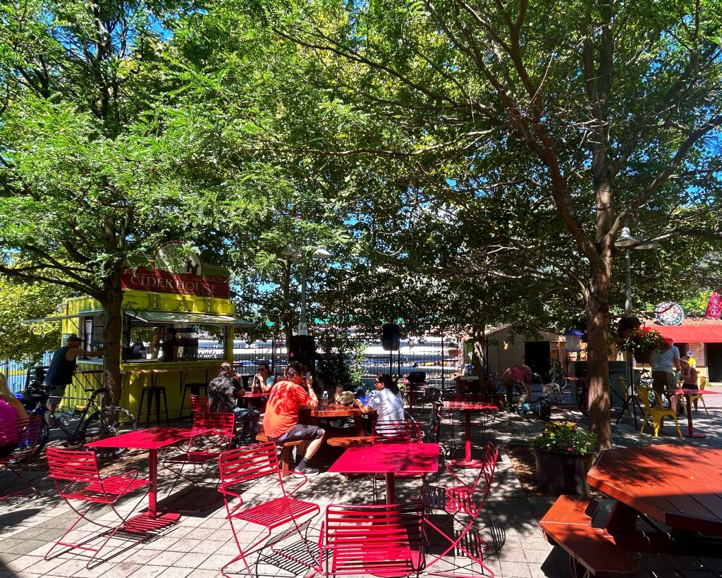 cosmic cafe with dappled light on red tables and green trees