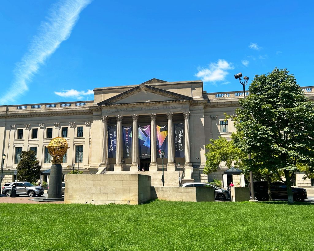 columns of the entrance to the franklin institute behind green lawn