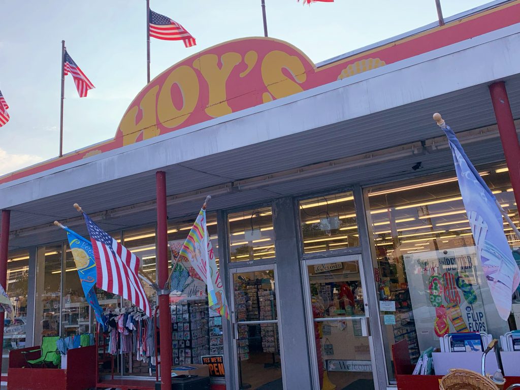 doors of a store with red and yellow hoys sign and flags