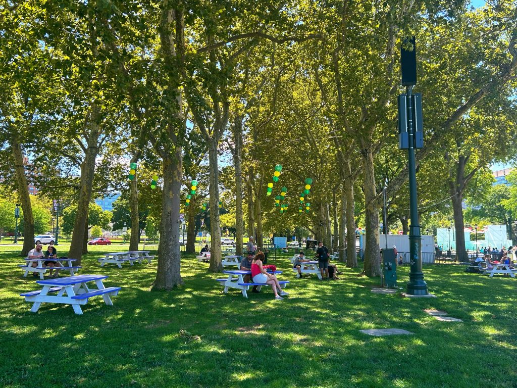 picnic tables in the oval plaza park with green grass and trees