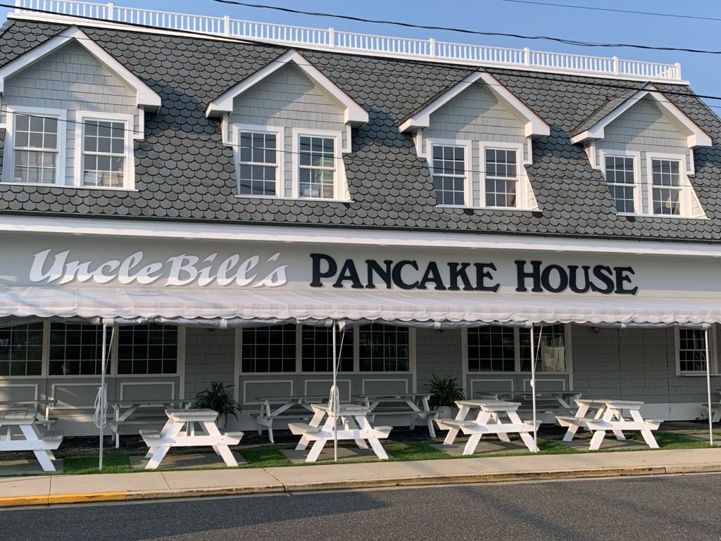 gray building with picnic tables in front