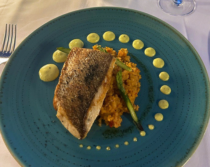 chicken and rice on a blue plate with sauce surrounding it