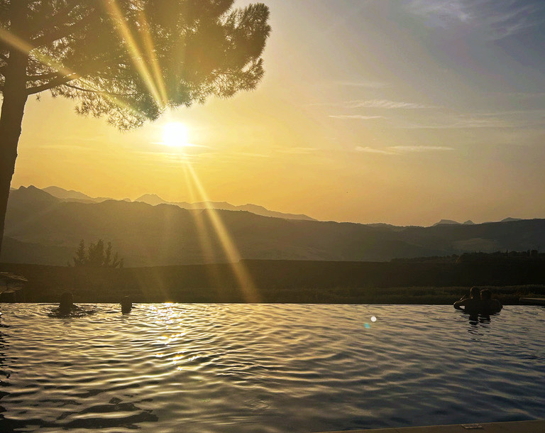 infinity pool looking out over mountains at sunset