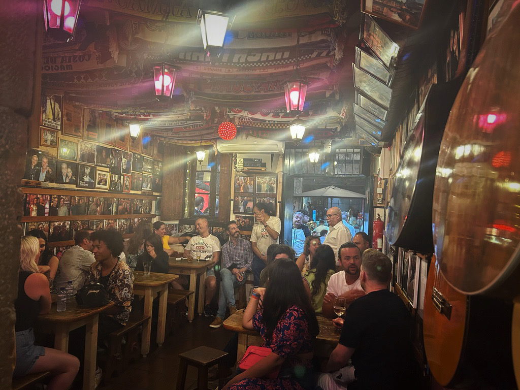 crowded fado club with guitars and photos on the walls